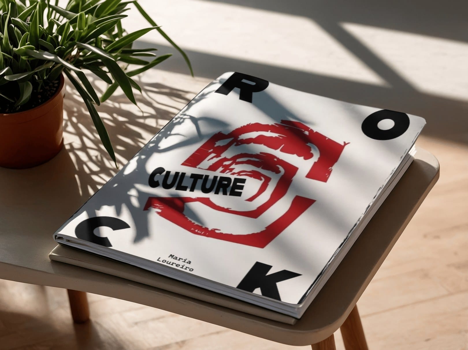 Rock Culture magazine lying on a wooden stool in dappled light, red brushstroke artwork on a white cover